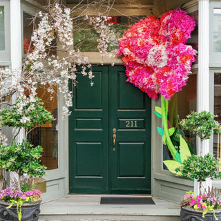 The front door of Cate's Boutique, decorated for spring with real flowers and a giant flower decoration.